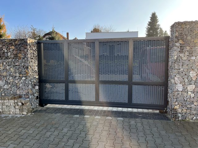 Painted sliding gate by a gabion fence
